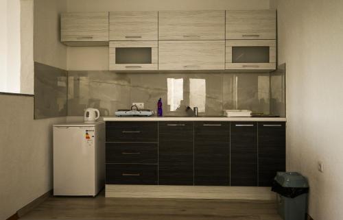 una cucina con armadi neri e frigorifero bianco di Apartman Pavić a Livno