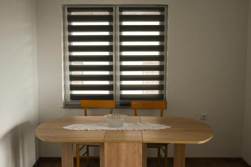 un tavolo da pranzo con due sedie e una finestra di Apartman Pavić a Livno