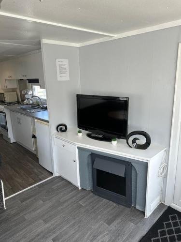 a living room with a flat screen tv on a entertainment center at Colemans Caravans 3 Bedroom 6 Birth Caravan Golden Anchor Caravan Park in Chapel Saint Leonards