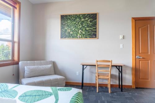 a bedroom with a desk and a chair and a table at Whalers Guesthouse in Tofino
