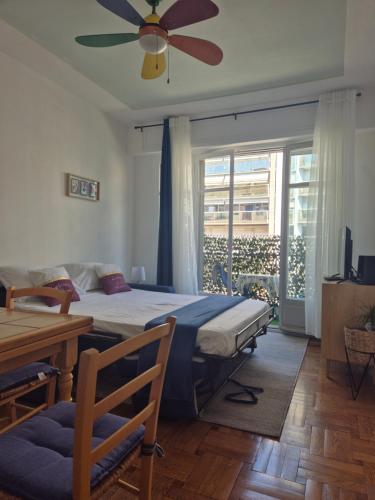 une chambre avec un lit et un ventilateur de plafond dans l'établissement Le Grand Sud, à Nice