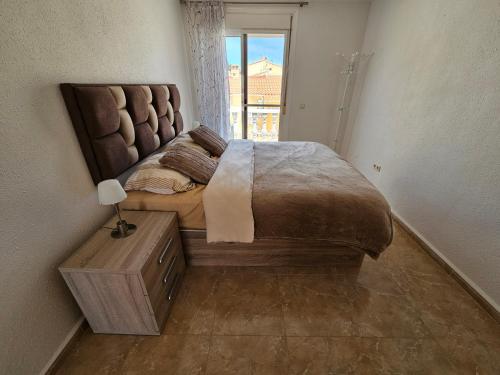 a bedroom with a large bed and a window at Cozy Townhouse in San Fulgencio