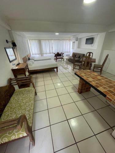 a living room with a couch and a table at Hotel Oasis Cuyutlan in Cuyutlán