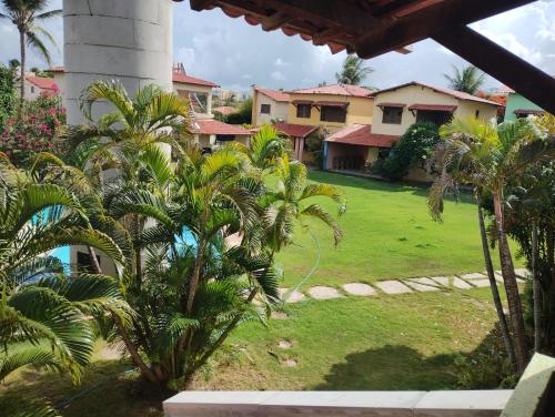 a view of a yard with palm trees and houses at Apartamento kite surfe Cumbuco Tabuba in Caucaia