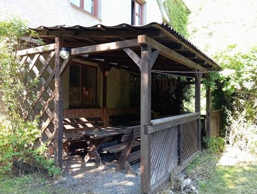 a wooden pergola on the side of a house at Stará škola - studio apartmán, 4 lůžka in Čaková