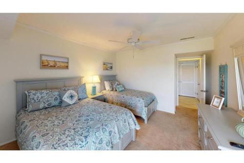 a bedroom with two beds and a ceiling fan at 2 BR Condo in Inlet Point Stunning Views in Pawleys Island