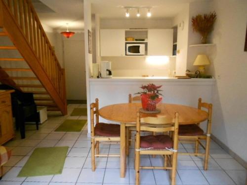 une cuisine avec une table et des chaises et une cuisine avec un comptoir dans l'établissement Résidence Pic De Lia - Appartement 6 personnes au centre du village MAE-6164, à Cadeilhan-Trachère