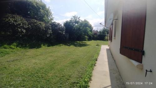 a field of grass next to a building at Chambre chez l'habitant in Boudy