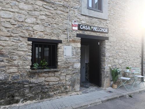 a stone building with a sign that reads cassis vacation at Casa MELCHOR in Villanúa