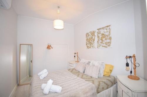a bedroom with a bed with white towels on it at Moradia Estoril in Estoril