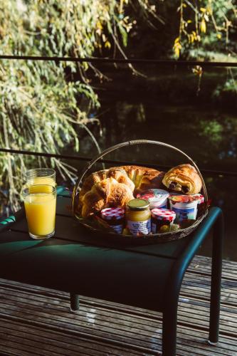 - une table avec un panier de nourriture et un verre de jus d'orange dans l'établissement La Cabane du Pont de l'Ignon, à Frénois