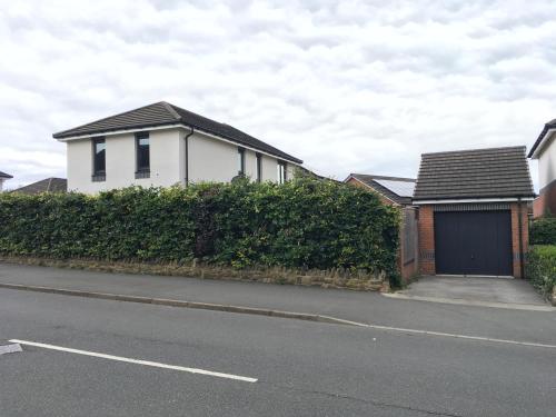 a white house with a garage on the side of a street at Family Room 2 beds Free WiFi Free Parking in Hillsborough