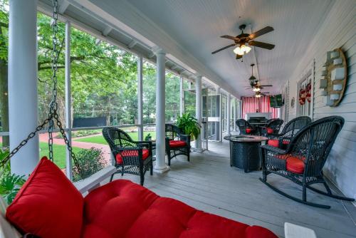 a screened porch with a red couch and chairs at Bama Bed and Breakfast - Tusk Suite in Tuscaloosa