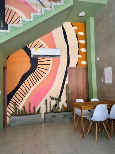 a mural in a lobby with chairs and a table at Hotel Paranawa in Baranoa