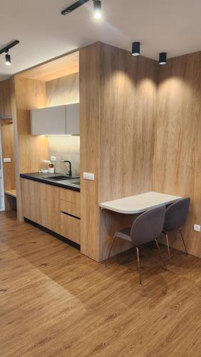 a kitchen with a table and a sink and a counter at Apartmani Dobrinja - Free parking- Rent a car in Sarajevo