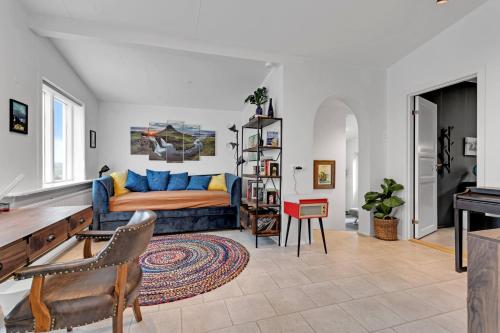 a living room with a couch and a table at 3BR Spacious Cottage with Geothermal HotTub & Stunning View in Laugaras