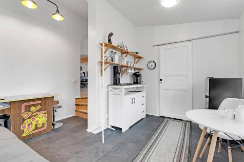 a kitchen and dining room with a table and a refrigerator at 3BR Spacious Cottage with Geothermal HotTub & Stunning View in Laugaras