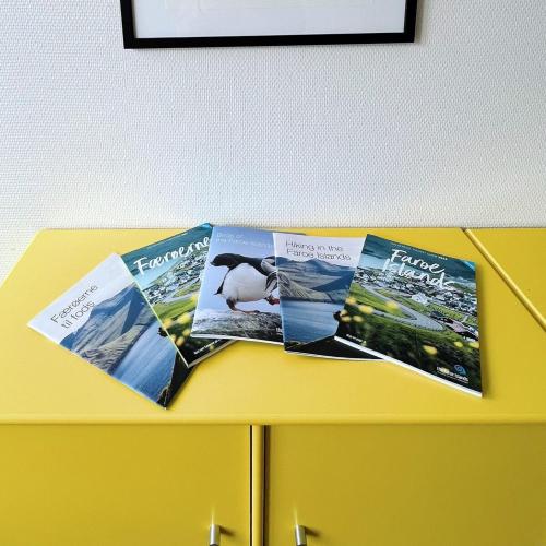 drei Zeitschriften auf einem gelben Tisch in der Unterkunft Experience Trshavn's Vibrant Culture in Tórshavn