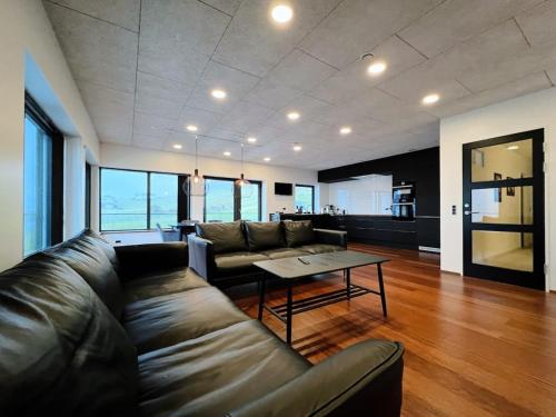 a living room with a couch and a table at Stunning Ocean View Penthouse Apartment in Øravík