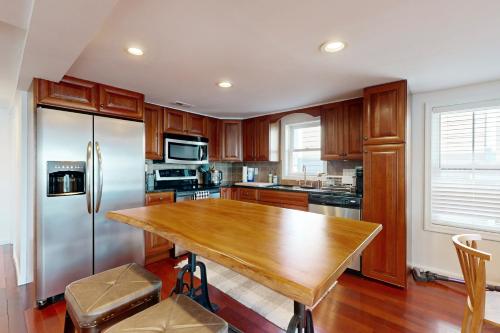 a kitchen with a wooden table and stainless steel refrigerator at Town of Lewes --- 119 Front St. in Lewes