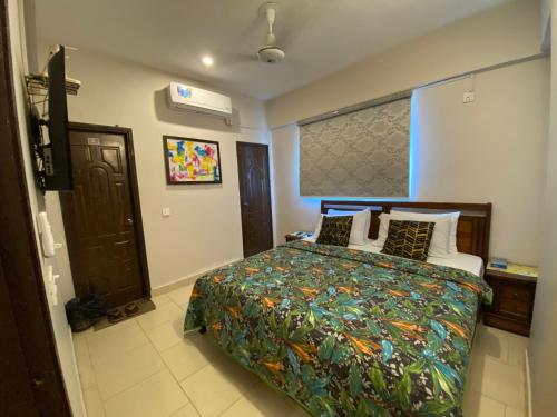 Un dormitorio con una cama con una colcha colorida. en 2 Bedroom Apartment in DHA, en Karachi