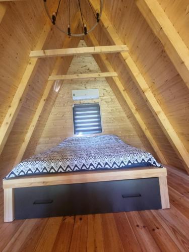 a bed in a loft with a window at OASIS of PEACE 1 in Šavnik