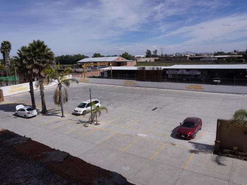 a parking lot with three cars parked in it at Hotel Real de La Barca in La Barca