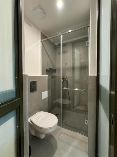 a bathroom with a toilet and a glass shower at Mosh Mosh Boutique Hotel in Almaty