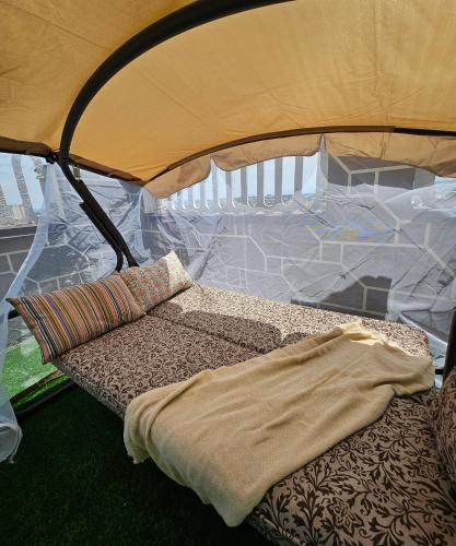 a bed under a tent with a blanket on it at PENTHOUSE - HORIZON of KHUJAND in Khujand