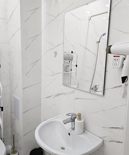 a white bathroom with a sink and a mirror at PENTHOUSE - HORIZON of KHUJAND in Khujand