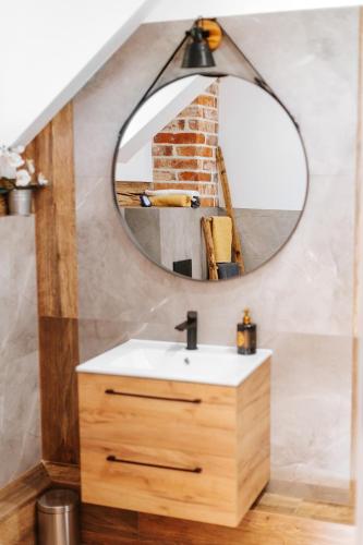 a bathroom with a sink and a mirror at JÓZEFÓWKA Stara Stodoła in Zagórze