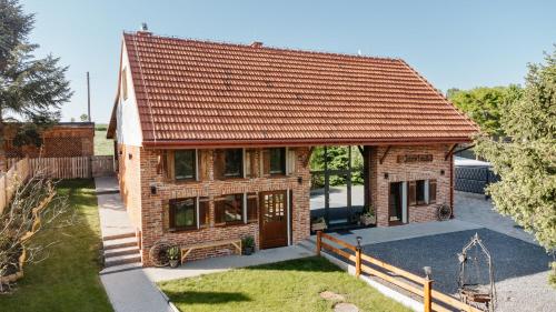 a brick house with a red roof at JÓZEFÓWKA Stara Stodoła in Zagórze