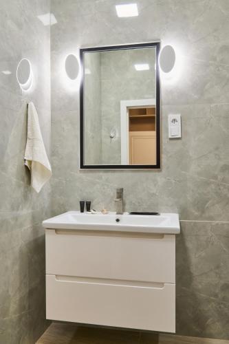 a bathroom with a white sink and a mirror at Five Business-class rooms in R-house near Mega Center Almaty in Almaty