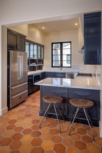 a large kitchen with a large island with two stools at Hotel San Buena in Ventura