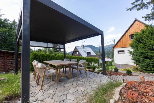 a patio with a wooden table and chairs at Chata Ostravice pod Smrkem in Ostravice
