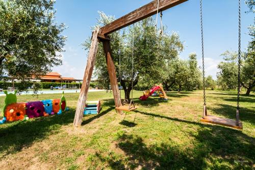 a playground with swings in a park at Agriturismo Il Giglio di Sant' Antonio in Montemassi