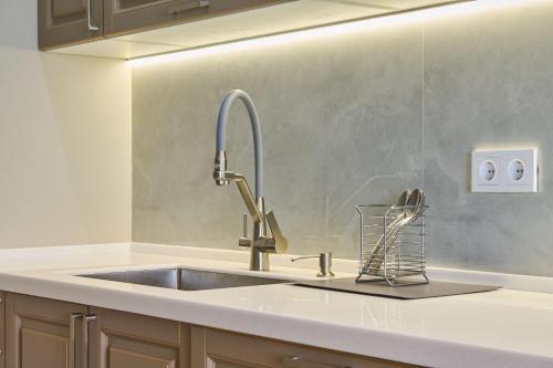 Un fregadero de cocina con un grifo sobre una encimera en LUX Spacious New ap near MEGA, en Almaty