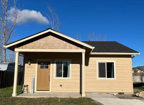 a small house with a door in a yard at Charming 2BR Cottage Near Freeway-Cul-de-sac in Medford