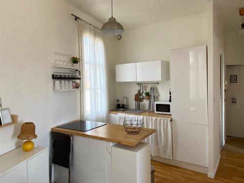 une cuisine avec des armoires blanches et un réfrigérateur blanc dans l'établissement T2 vue mer Toulon plage Mourillon, à Toulon