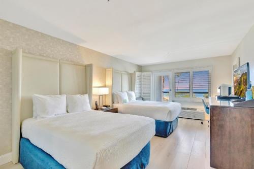 a hotel room with two beds and a television at Ocean View Hotel in Los Angeles