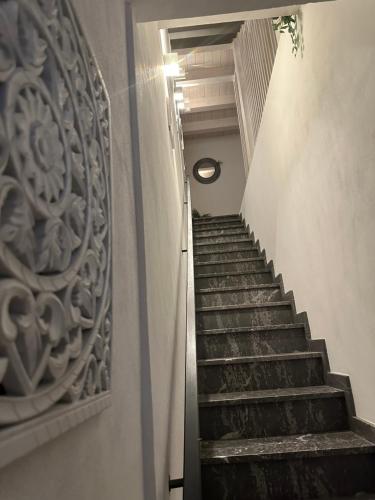 a stairway leading up to a building with a stone wall at L'Oasi del Tirreno in Lascari