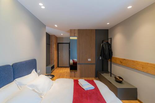 a bedroom with a bed with a red blanket at Prado Apartments in Pristina