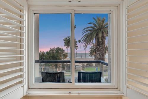 a window with a view of a palm tree at Ocean View Hotel in Los Angeles