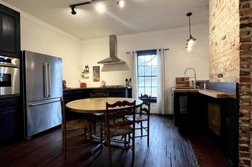 a kitchen with a table and chairs and a refrigerator at Renovated Mill House in Historic Golden Belt in Durham
