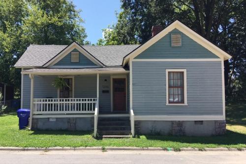 a blue house with a porch and a window at Renovated Mill House in Historic Golden Belt in Durham