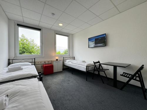 a hospital room with two beds and a table at Thuja Apartments Karlsruhe-Neureut by KurzZeit in Karlsruhe