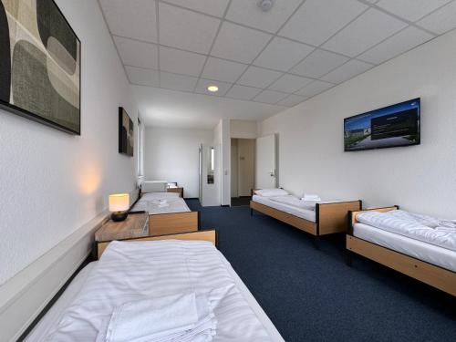 a hospital room with three beds and a room with at Thuja Apartments Karlsruhe-Neureut by KurzZeit in Karlsruhe