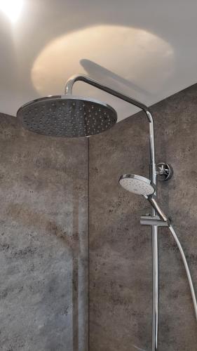 a shower with a shower head in a bathroom at Hotel De Lange Akker in Berg en Terblijt