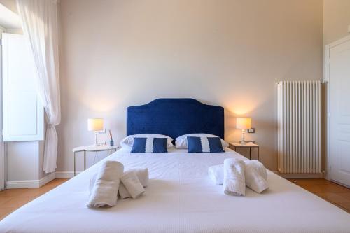 a bedroom with a large white bed with blue headboard and pillows at Palazzo Gargano in Prignano Cilento