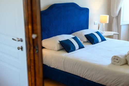 a bed with a blue headboard and pillows on it at Palazzo Gargano in Prignano Cilento